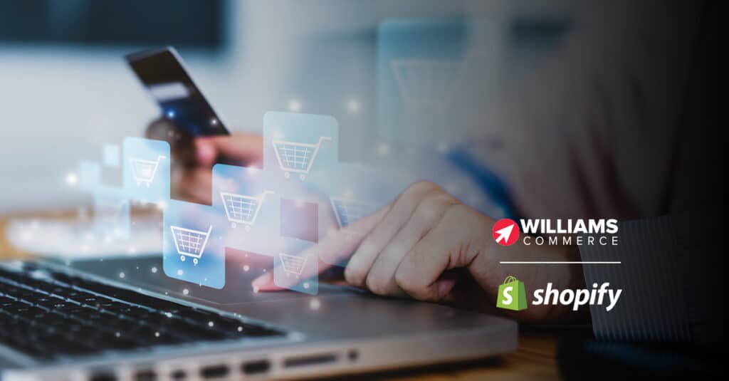 Person's finger on laptop trackpad and holding a mobile phone in the other hand. Icons of shopping trollies hover above the laptop trackpad. Williams Commerce and Shopify logos are featured on the right.